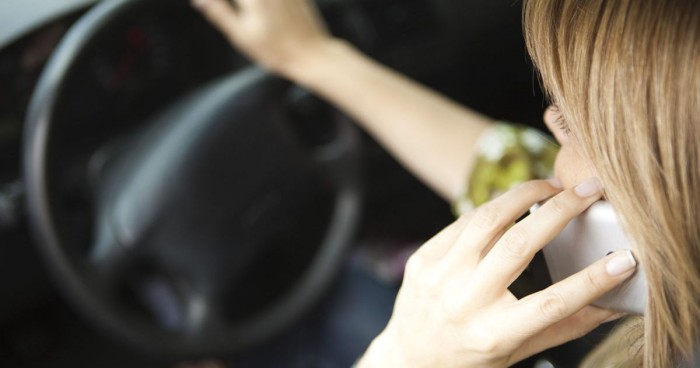 woman-using-mobile-phone-while-driving